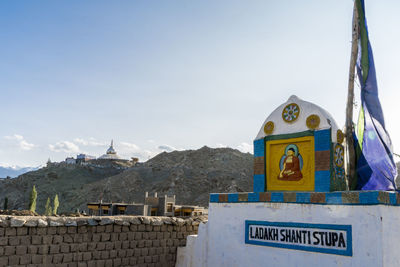 Information sign on mountain against sky