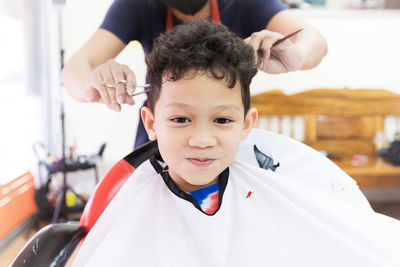 Close-up portrait of boy sitting at hair salon