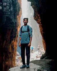 Portrait of young man standing on rock formation