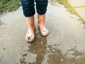 Low section of person standing in puddle