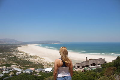 Rear view of woman looking at sea against sky