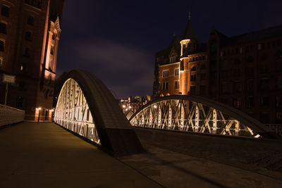 Bridge over river in city at night