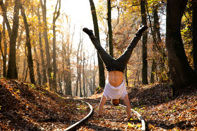 Man doing handstand on land in forest