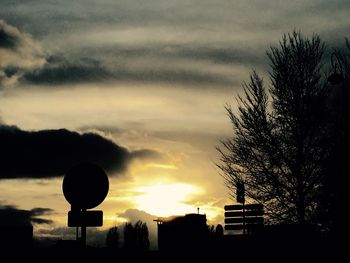 Low angle view of silhouette trees against cloudy sky