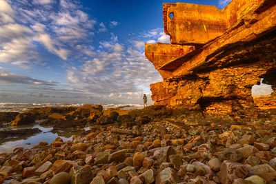 View of rock formation against cloudy sky