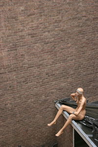 Mannequin against brick wall