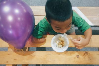 High angle view of handicap boy eating food at table