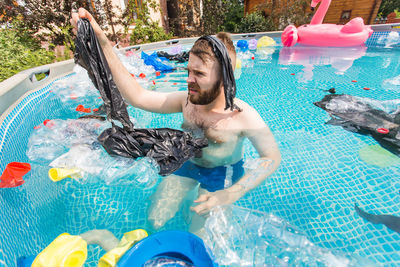 Full length of shirtless man in swimming pool