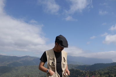 Man standing on mountain against sky