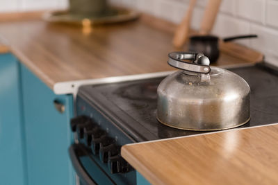 Dirty metal kettle with stains on an induction hob