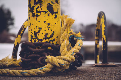 Close-up of rope and chain on bollard