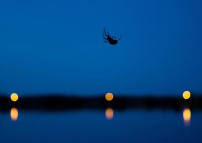 Close-up of moon over sea against clear blue sky