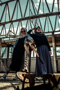 Portrait of two muslim woman model standing against built structure