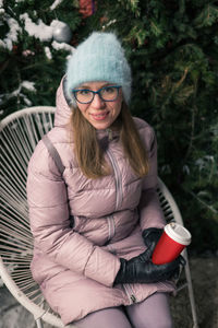 Portrait of young woman sitting in park