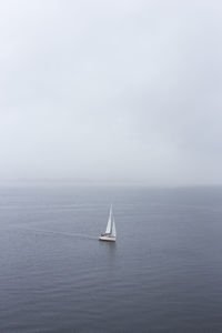 Sailboat sailing on sea against clear sky