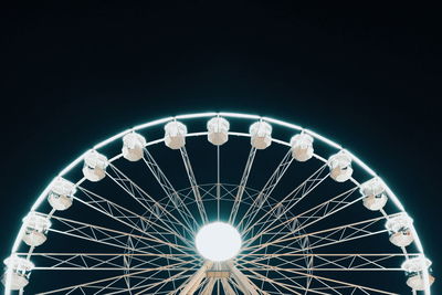 Low angle view of illuminated ferris wheel against sky at night