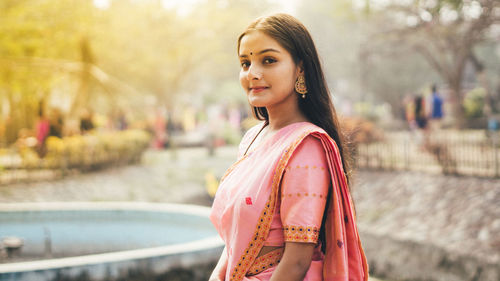 Portrait of smiling young woman standing outdoors