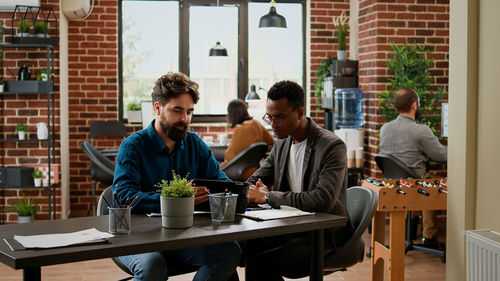 Portrait of smiling friends sitting at restaurant