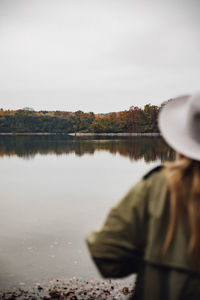 Rear view of woman in lake against sky