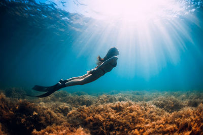 Low section of woman swimming in sea