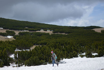 Full length of man standing on snow covered landscape