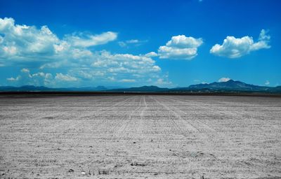 Scenic view of barren landscape against blue sky