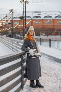 Rear view of woman standing on railing