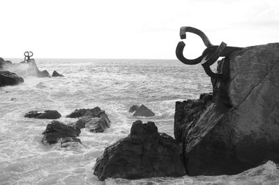 Close-up of sculpture on beach against sky