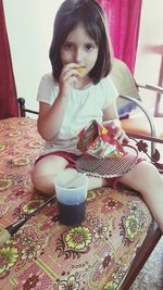 Portrait of a girl sitting on table at home