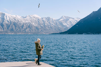 Full length of woman standing by lake