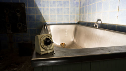 Vintage timer on bathtub in abandoned bathroom