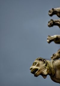 Low angle view of gargoyles against clear sky