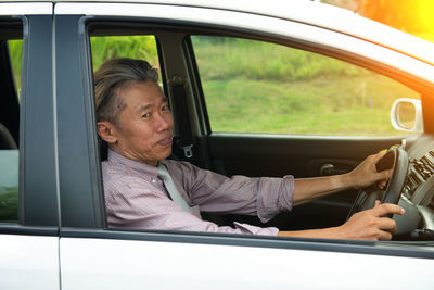 Portrait of man sitting in car