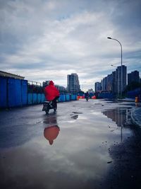 Man in city against sky