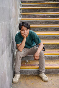 Portrait of young man sitting on steps