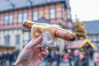 Close-up of hand holding bratwurst on christmas market