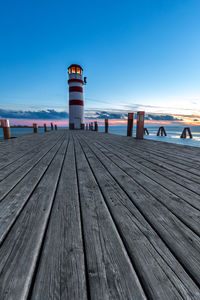 Wooden pier on beach against clear blue sky