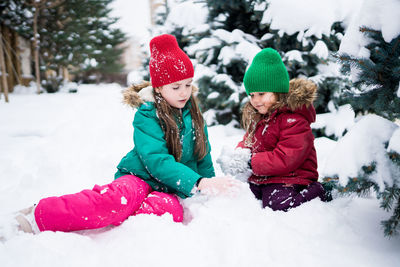 Cute girls playing on snow covered land