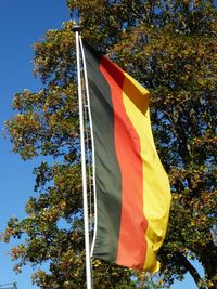 Low angle view of flag against blue sky