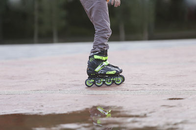 Low section of person skating on wet road