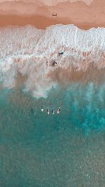 Aerial view of people surfing in sea