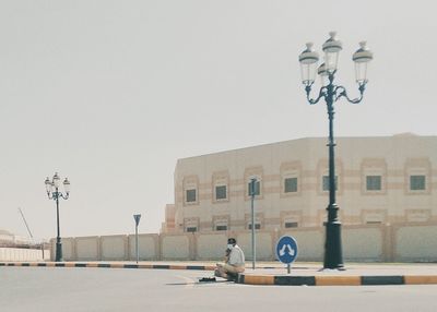 Man riding motorcycle on road against buildings