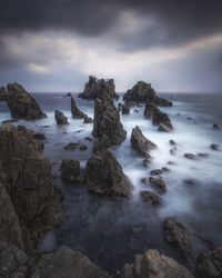 Scenic view of rocks in sea against sky