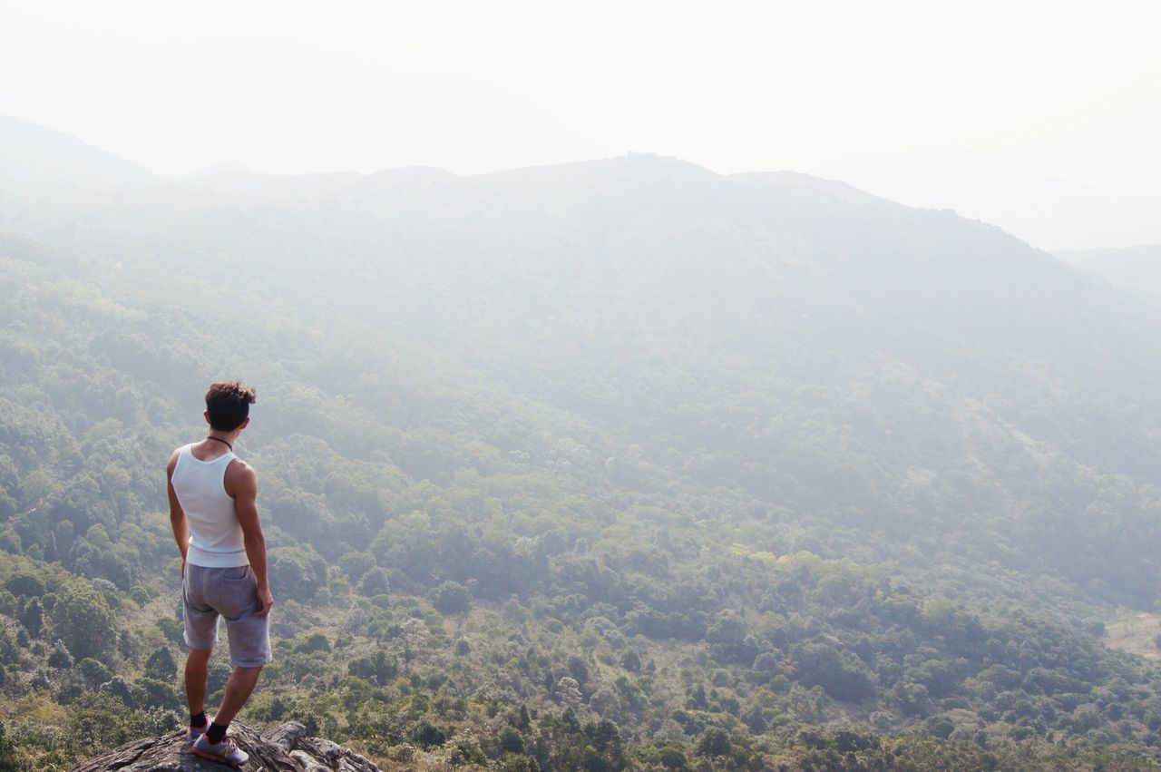 mountain, lifestyles, leisure activity, casual clothing, landscape, mountain range, scenics, tranquility, standing, rear view, full length, tranquil scene, beauty in nature, looking at view, nature, men, hiking, young adult