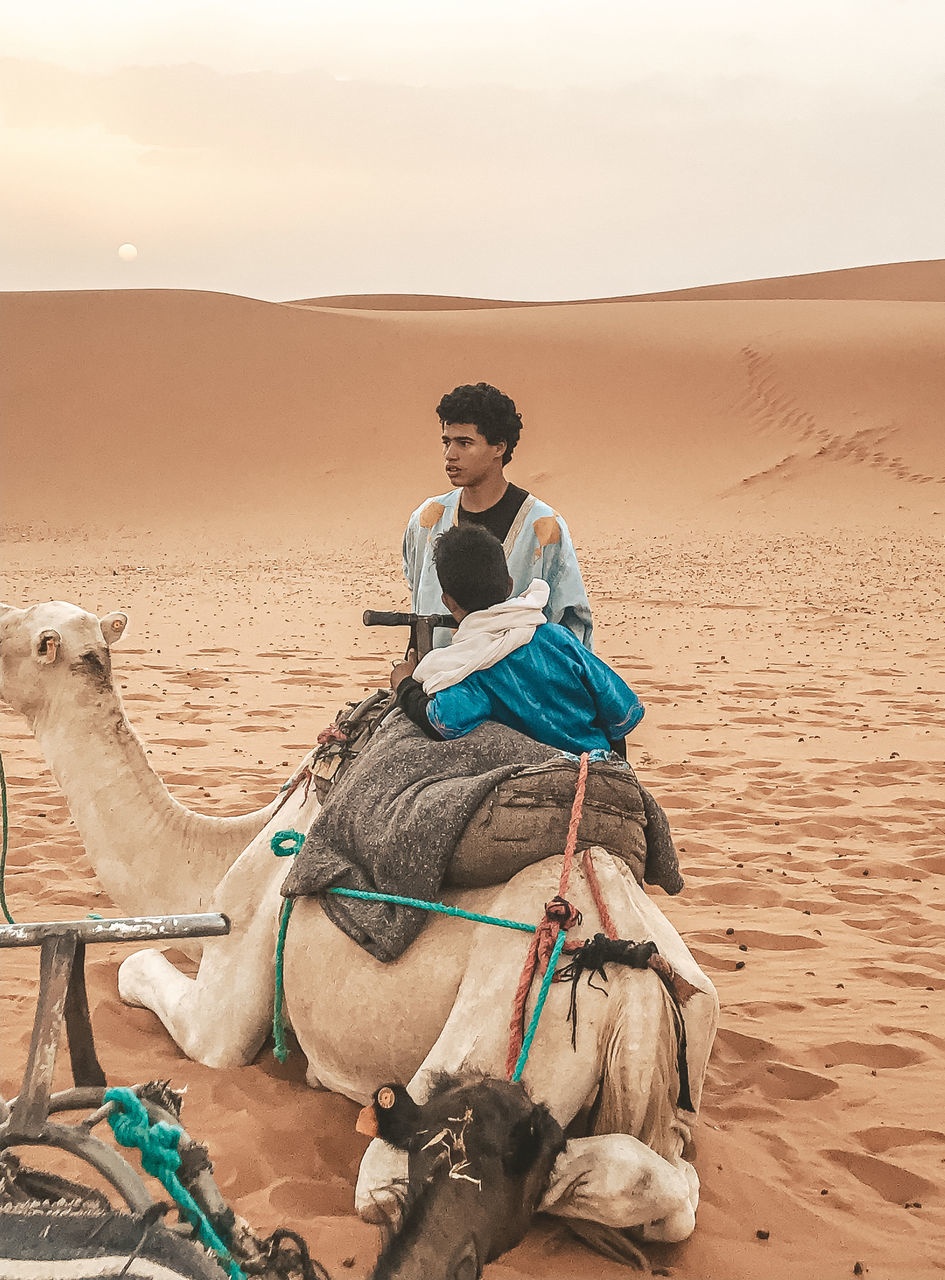 MAN RIDING MOTORCYCLE ON SAND