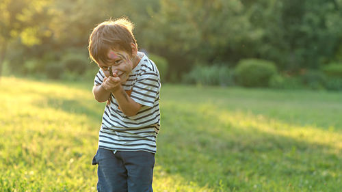 Side view of boy standing on field