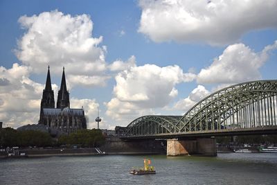 Bridge over river against cloudy sky