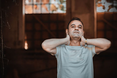 Portrait of man standing against house