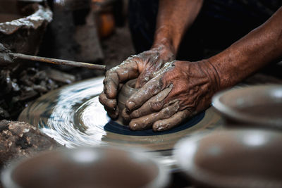 Cropped hands of man making pottery in workshop