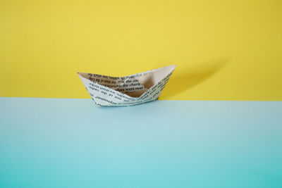 High angle view of paper boat on colored background